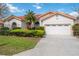 Charming single-story home with a well-manicured lawn, a two-car garage, and a red tile roof at 8824 Havenridge Dr, Sarasota, FL 34238