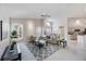 Spacious living room features a ceiling fan, large windows, and open design to the kitchen and dining area at 8824 Havenridge Dr, Sarasota, FL 34238