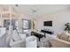 Open concept living room with neutral tones, vaulted ceilings, and access to outdoor pool area at 8824 Havenridge Dr, Sarasota, FL 34238