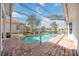 Screened-in pool and patio area offers a beautiful view of the surrounding lake and landscaping at 8824 Havenridge Dr, Sarasota, FL 34238