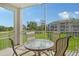 Outdoor balcony with a table and chairs offering serene views of lush greenery and distant building at 9630 Club South Cir # 6209, Sarasota, FL 34238