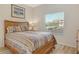 Cozy bedroom with a queen bed, wood laminate flooring, and a bright window overlooking the beautiful neighborhood at 9630 Club South Cir # 6209, Sarasota, FL 34238