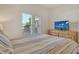 Comfortable bedroom featuring a queen bed, wood dresser, and a bright window with nice outside views at 9630 Club South Cir # 6209, Sarasota, FL 34238