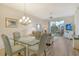 Inviting dining room with a glass table, chandelier, and seamless transition to a living area and balcony at 9630 Club South Cir # 6209, Sarasota, FL 34238