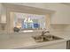 Pass through kitchen featuring stainless steel sink, white countertops and view to the living room at 9630 Club South Cir # 6209, Sarasota, FL 34238