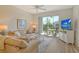 Comfortable living room featuring neutral tones, sliding doors to balcony and light wood floors at 9630 Club South Cir # 6209, Sarasota, FL 34238