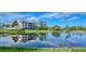 Scenic view of a pond reflecting a building on a sunny day, surrounded by lush landscaping at 9630 Club South Cir # 6209, Sarasota, FL 34238