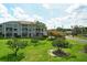 Screened-in lanai offering a beautiful view of the lush green lawn and condo buildings in a private community at 9630 Club South Cir # 6209, Sarasota, FL 34238