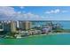 Stunning aerial view of luxury condos overlooking turquoise water, sandy beaches, and a vibrant city skyline at 99 Sunset Dr # 102, Sarasota, FL 34236