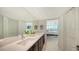 Primary bathroom featuring double sinks with view of bedroom and natural light throughout at 99 Sunset Dr # 102, Sarasota, FL 34236