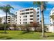 Beautifully landscaped condominium building with lush greenery, mature palm trees, and ample natural light at 99 Sunset Dr # 102, Sarasota, FL 34236
