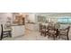 Charming dining area with a glass table and seating for six adjacent to the kitchen at 99 Sunset Dr # 102, Sarasota, FL 34236