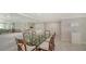 Bright dining room with a glass table and seating for six with a decorative mirror wall at 99 Sunset Dr # 102, Sarasota, FL 34236
