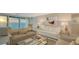 Bright living room features neutral furnishings and expansive sliding glass doors with ocean views at 99 Sunset Dr # 102, Sarasota, FL 34236