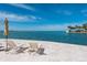 Relaxing lounge area with chairs and umbrella overlooking a scenic ocean view at 99 Sunset Dr # 102, Sarasota, FL 34236