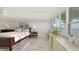 Bright main bedroom with a wall of windows offering breathtaking waterfront views and marble floors at 99 Sunset Dr # 102, Sarasota, FL 34236