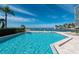 Relaxing waterfront pool with lounge chairs, umbrellas, and serene ocean views at 99 Sunset Dr # 102, Sarasota, FL 34236
