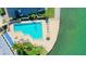 Aerial view of a community pool area with lounge chairs, umbrellas, and lush greenery at 99 Sunset Dr # 102, Sarasota, FL 34236