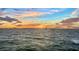 Dramatic waterfront view at sunset, featuring calm waters and colorful skies at 99 Sunset Dr # 102, Sarasota, FL 34236