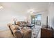 A comfortable living room with a ceiling fan, leather sofas, and view of water from the balcony at 1020 Tidewater Shores Loop # 304, Bradenton, FL 34208