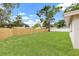 Spacious back yard with well-maintained lawn and a new wooden fence behind the white home at 1050 55Th S Ave, St Petersburg, FL 33705