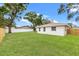 Spacious back yard with well-maintained lawn with privacy fence behind the white home at 1050 55Th S Ave, St Petersburg, FL 33705