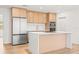 Modern kitchen with stainless steel appliances, including a refrigerator, oven, and microwave, with light wood cabinets at 1050 55Th S Ave, St Petersburg, FL 33705