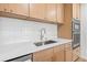 This modern kitchen has bright, white quartz countertops and sleek, maple-colored wood cabinetry at 1050 55Th S Ave, St Petersburg, FL 33705