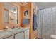 Compact bathroom featuring a single sink vanity, framed mirror, and a shower-tub combination with a patterned curtain at 1110 49Th Avenue W Dr, Bradenton, FL 34207