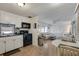 Cozy kitchen featuring a black appliance suite, white cabinetry, and an adjacent living area at 1110 49Th Avenue W Dr, Bradenton, FL 34207