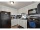 Functional kitchen with white cabinetry, backsplash, and black appliances at 1110 49Th Avenue W Dr, Bradenton, FL 34207