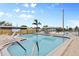 Community pool with lounge chairs, palm trees, and a lake view at 1110 49Th Avenue W Dr, Bradenton, FL 34207