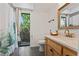 Bathroom features a light wood vanity, modern fixtures and a tropical view from the window at 11219 93Rd St, Largo, FL 33773