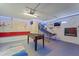 Spacious game room featuring a foosball table, basketball setup, neon lights, and comfortable seating at 11219 93Rd St, Largo, FL 33773