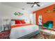 Bright bedroom featuring a large bed, an orange accent wall, and colorful decor at 11219 93Rd St, Largo, FL 33773