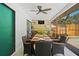 A full outdoor dining setup featuring a ceiling fan, bar, and wall-mounted television at 11219 93Rd St, Largo, FL 33773