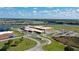 Community aerial view showcasing a modern school building, lake, and surrounding neighborhood homes and parking at 12029 Cranston Way, Lakewood Ranch, FL 34211