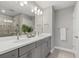 Bathroom with double sink vanity, gray cabinetry, large mirror, and tiled shower with glass door at 12029 Cranston Way, Lakewood Ranch, FL 34211