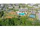 Aerial view showcasing community amenities including a swimming pool, tennis court, playground and lush landscaping at 12029 Cranston Way, Lakewood Ranch, FL 34211
