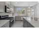 Contemporary kitchen with stainless appliances, gas range and light gray cabinets offers a modern aesthetic at 12029 Cranston Way, Lakewood Ranch, FL 34211