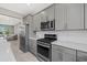 Stylish kitchen with gray cabinetry, stainless steel appliances, and sleek countertops, designed for modern living at 12029 Cranston Way, Lakewood Ranch, FL 34211