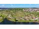 Aerial view of a community park featuring walking trails, green spaces, and landscaping surrounded by a lake at 12029 Cranston Way, Lakewood Ranch, FL 34211