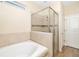 Bright bathroom featuring a soaking tub and glass-enclosed shower with beige tiling at 12592 Ryegrass Loop, Parrish, FL 34219
