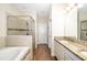 A luxurious bathroom features a glass shower, a soaking tub, granite countertops, and elegant fixtures at 12592 Ryegrass Loop, Parrish, FL 34219