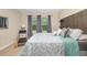 A well-lit bedroom features a comfortable bed, a stylish headboard, and natural light from the window at 12592 Ryegrass Loop, Parrish, FL 34219