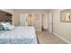 A cozy bedroom showcases a patterned bedspread, soft carpet, and doors leading to the hallway and the bathroom at 12592 Ryegrass Loop, Parrish, FL 34219