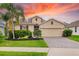Charming single-Gathering home featuring a well-manicured lawn, lush landscaping, and a brick-paved driveway at 12592 Ryegrass Loop, Parrish, FL 34219