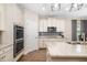 Bright kitchen features stainless steel appliances, double oven, custom cabinetry, and stone countertops at 12592 Ryegrass Loop, Parrish, FL 34219