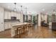 An open-concept kitchen with stainless steel appliances, granite countertops, and wood floors leads to a dining and living space at 12592 Ryegrass Loop, Parrish, FL 34219