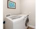 Laundry room with modern, white washer and dryer; light walls, dark trim at 12592 Ryegrass Loop, Parrish, FL 34219